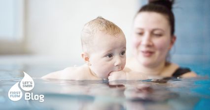 Baby im Wasser beim Babyschwimmen sucht Nähe zur Mutter – unsicherer Moment im Babyschwimmkurs