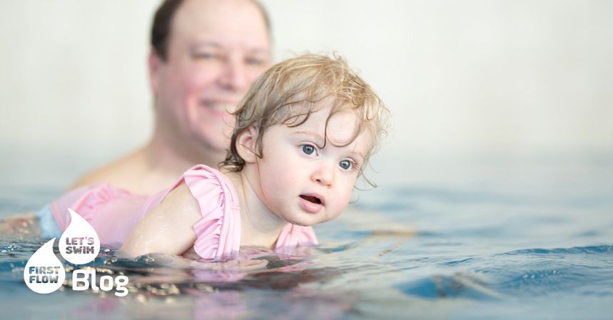 Baby im Wasser beim Babyschwimmen mit Vater– sammelt erste Bewegungs- und Sinneserfahrungen