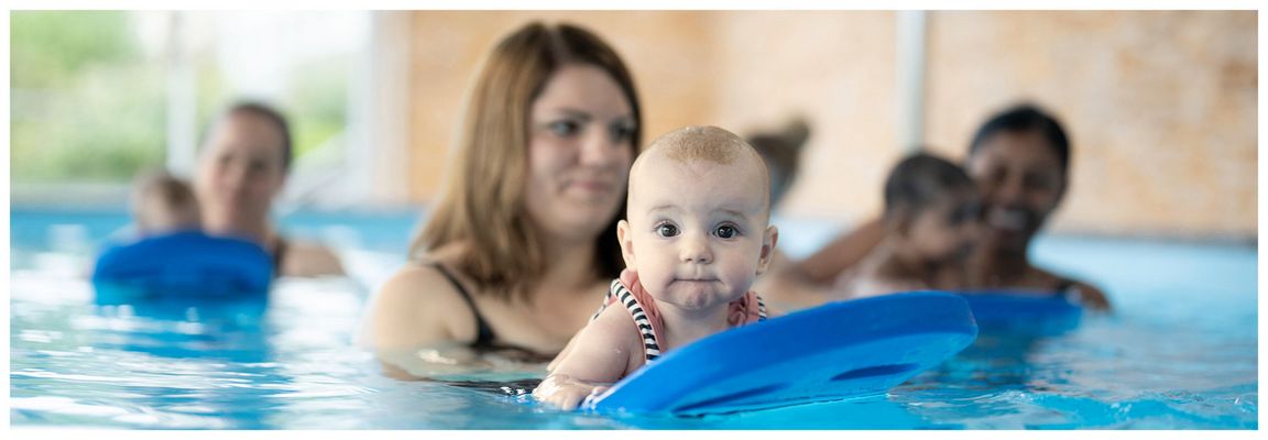 Babyschwimmen bei First Flow – Mama mit Baby im warmen Wasser beim Kurs